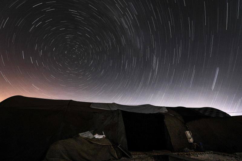Parece que el mundo se detiene al observar el cielo estrellado de Idlib (Siria). Sin embargo, basta con bajar un poco la mirada para darse cuenta de la realidad: edificios destruidos por una guerra que comenzó hace más de nueve años y que parece no tener fin, un campamento para sirios desplazados, un parque de atracciones abandonado y combatientes a lo largo de la primera línea con las fuerzas gubernamentales. Así son las noches en la provincia de Idlib, controlada por los rebeldes sirios. 