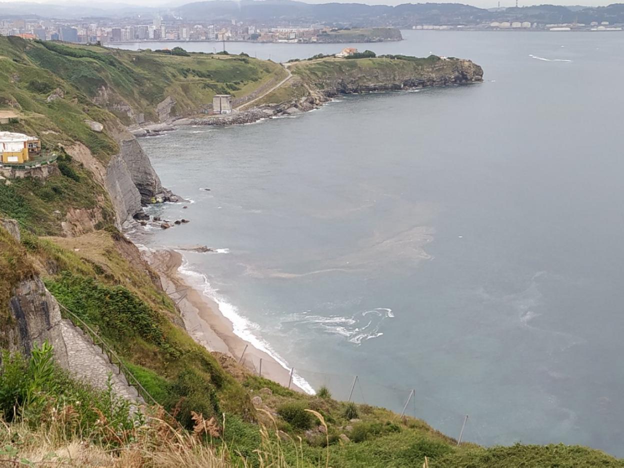 Playa de Peñarrubia, con las manchas en la mar. 