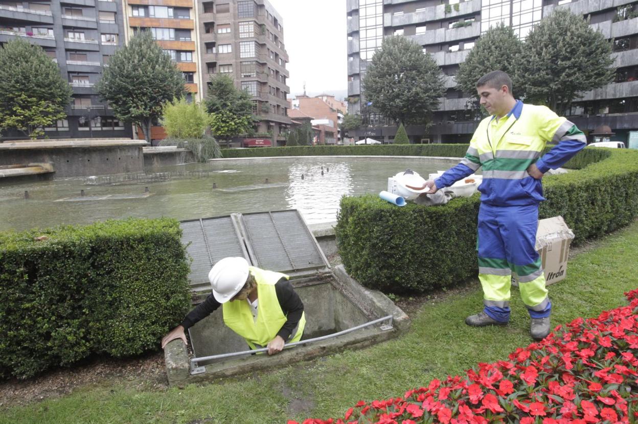 Operarios de Aqualia revisan la fuente de la plaza de América. 