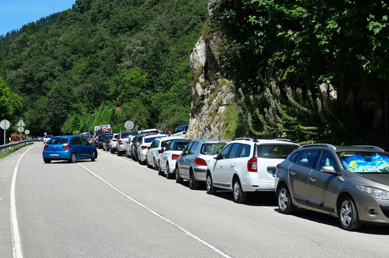 Coches estacionados en el arcén de la N-625 en Cangas. 