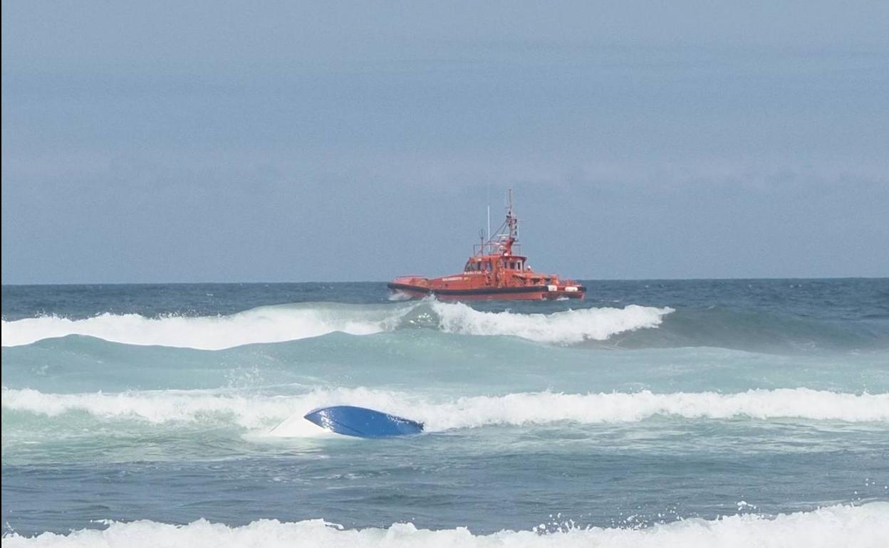 La embarcación, volcada en la playa de Xagó. 