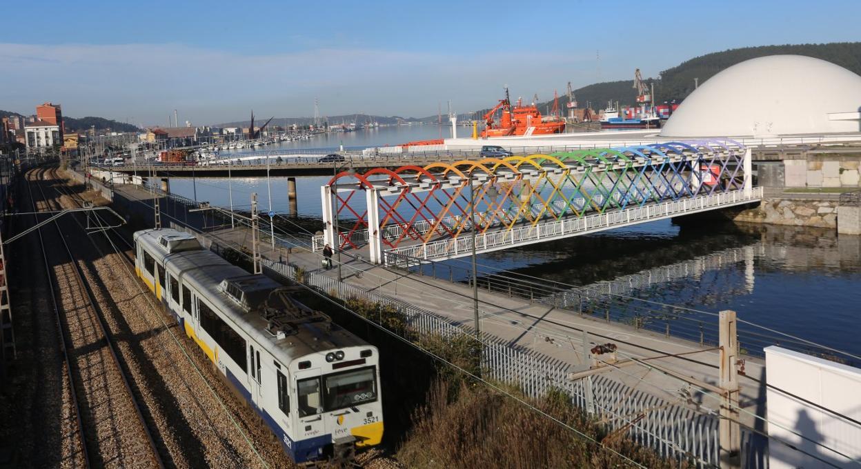 Un convoy de Feve circula por el tendido ferroviario que atraviesa Avilés en la calle de El Muelle, entre el casco histórico y la ría y el Niemeyer. 