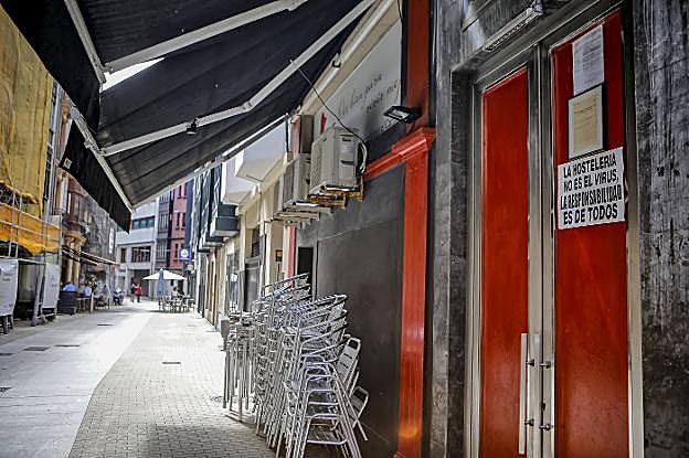 Cartel de protesta en un local de ocio en Gijón. En el vídeo, las nuevas medidas en Asturias de protección frente al coronavirus. 