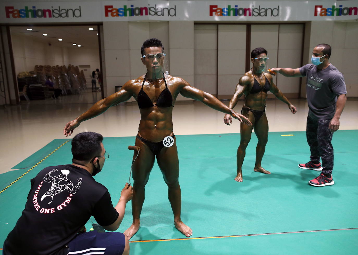 Protegidos con pantallas de plástico, decenas de concursantes compiten en el certamen de culturismo 'Mr. Tailandia' en Bangkok