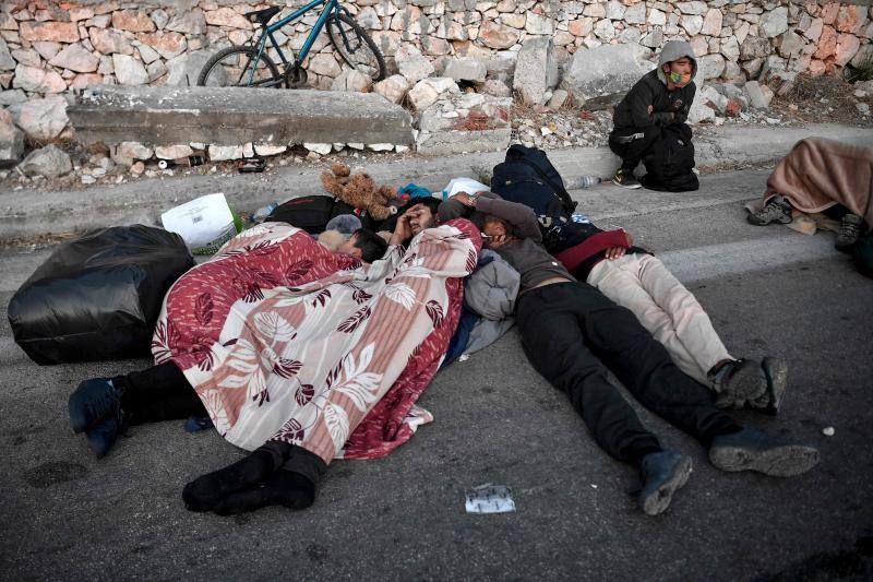 Miles de personas pasan la noche a la intemperie en los alrededores del devastado campo de refugiados de Moria (Lesbos), el más grande de Grecia, a la espera de ser trasladados. Las carreteras que rodean el campo, en el que malvivían 13.000 personas, están repletas de familias que con lo poco que les ha quedado se han instalado en la calzada o en alguna cercana al campo que no ha sido destruida por el incendio del martes por la noche; un incendio que comenzó simultáneamente en varios puntos del campo, poco después de que las autoridades comunicaran a 35 personas que habían dado positivo de covid-19 y que debían ser aisladas. 