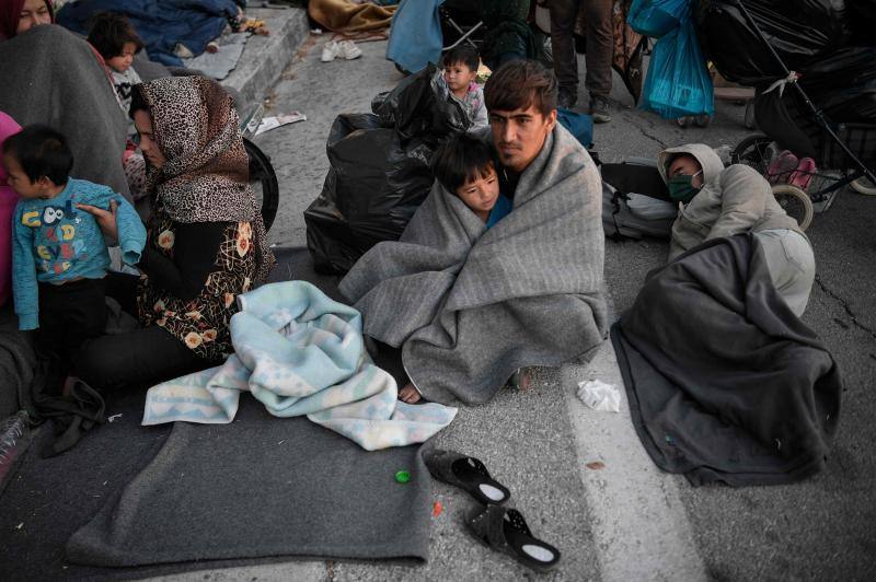 Miles de personas pasan la noche a la intemperie en los alrededores del devastado campo de refugiados de Moria (Lesbos), el más grande de Grecia, a la espera de ser trasladados. Las carreteras que rodean el campo, en el que malvivían 13.000 personas, están repletas de familias que con lo poco que les ha quedado se han instalado en la calzada o en alguna cercana al campo que no ha sido destruida por el incendio del martes por la noche; un incendio que comenzó simultáneamente en varios puntos del campo, poco después de que las autoridades comunicaran a 35 personas que habían dado positivo de covid-19 y que debían ser aisladas. 