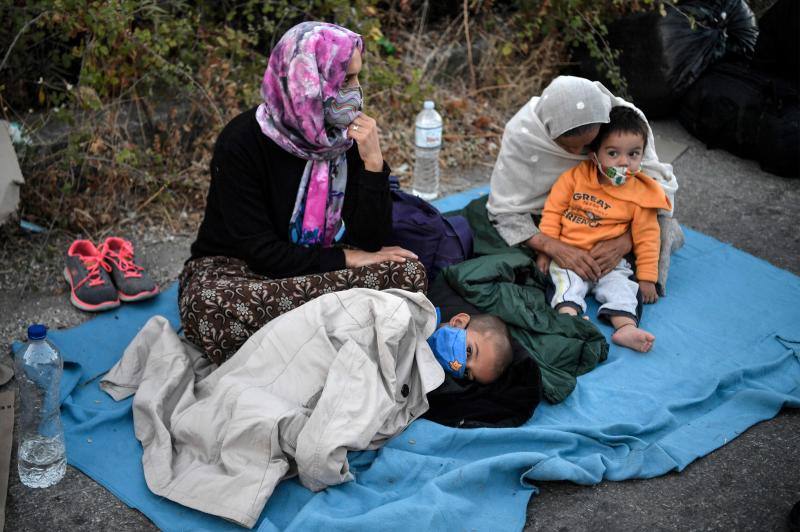 Miles de personas pasan la noche a la intemperie en los alrededores del devastado campo de refugiados de Moria (Lesbos), el más grande de Grecia, a la espera de ser trasladados. Las carreteras que rodean el campo, en el que malvivían 13.000 personas, están repletas de familias que con lo poco que les ha quedado se han instalado en la calzada o en alguna cercana al campo que no ha sido destruida por el incendio del martes por la noche; un incendio que comenzó simultáneamente en varios puntos del campo, poco después de que las autoridades comunicaran a 35 personas que habían dado positivo de covid-19 y que debían ser aisladas. 