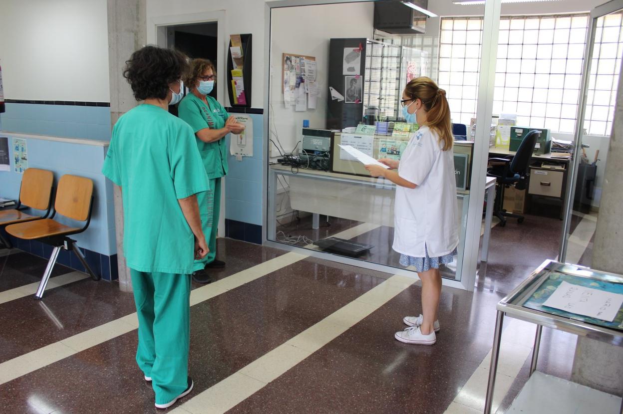 Raquel López de la Peña atiende a un paciente en Tremañes. A la derecha, trabajadoras de El Empalme preparan la jornada de trabajo. 