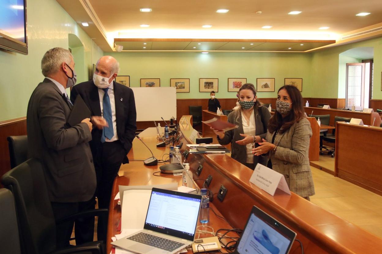 El rector, Santiago García Granda, conversa con Juan Antonio Pérez Simón en presencia de la secretaria del Consejo Social, Miriam Cueto Pérez (a la derecha). 