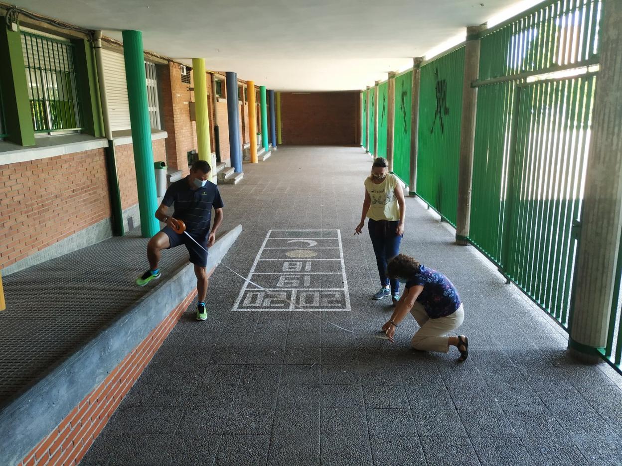 Carlos Diez, Marce Quintano y María Dolores Fernández toman medidas en el colegio Asturias de Gijón para garantizar la distancia de seguridad en el tránsito de los escolares de quinto y sexto de Primaria a su aula. 