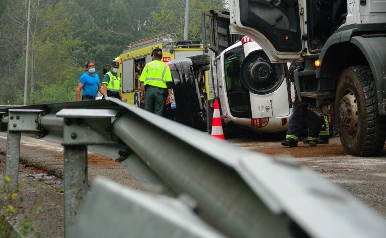 Agentes de la Guardia Civil, con el camión accidentado.