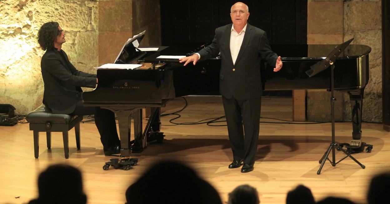 El tenor cangués Joaquín Pixán junto al piano de cola se dirige al público. 