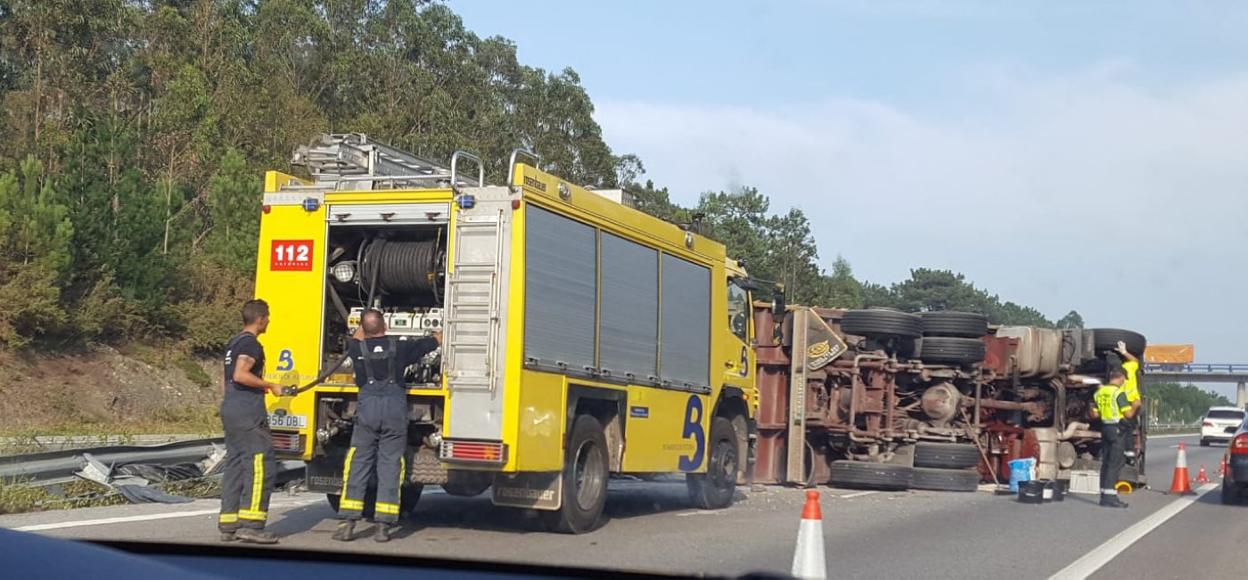 Bomberos y agentes de la Guardia Civil, en el lugar donde se produjo el accidente. 