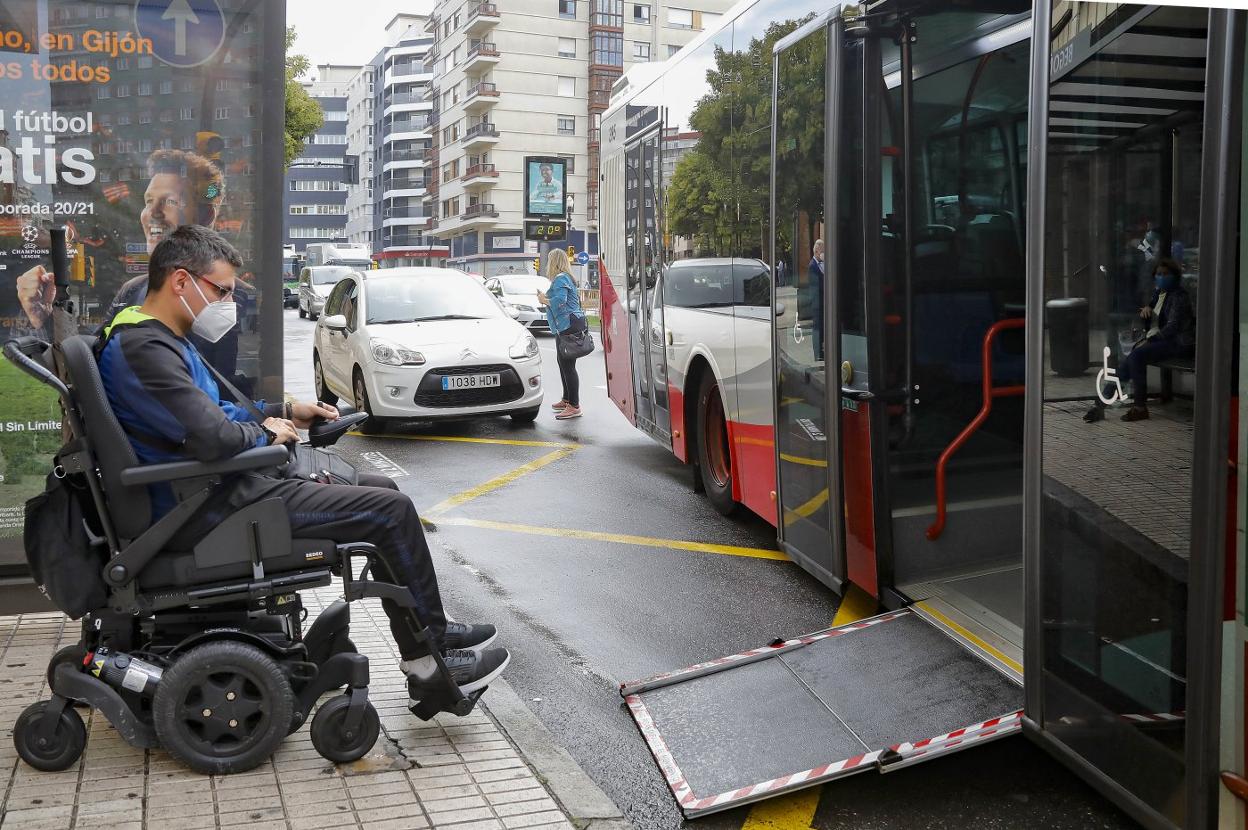Iván Sánchez, junto a un autobús que no puede desplegar su rampa sobre la acera por un estacionamiento indebido de demostración. 