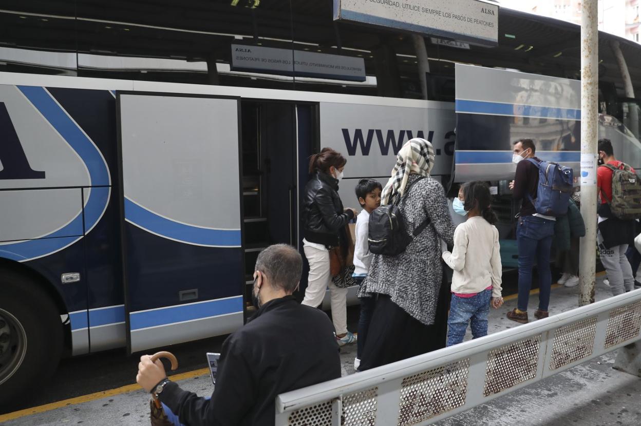 Pasajeros se bajan de un autobús procedente de Madrid, en la estación de Alsa de Gijón. 