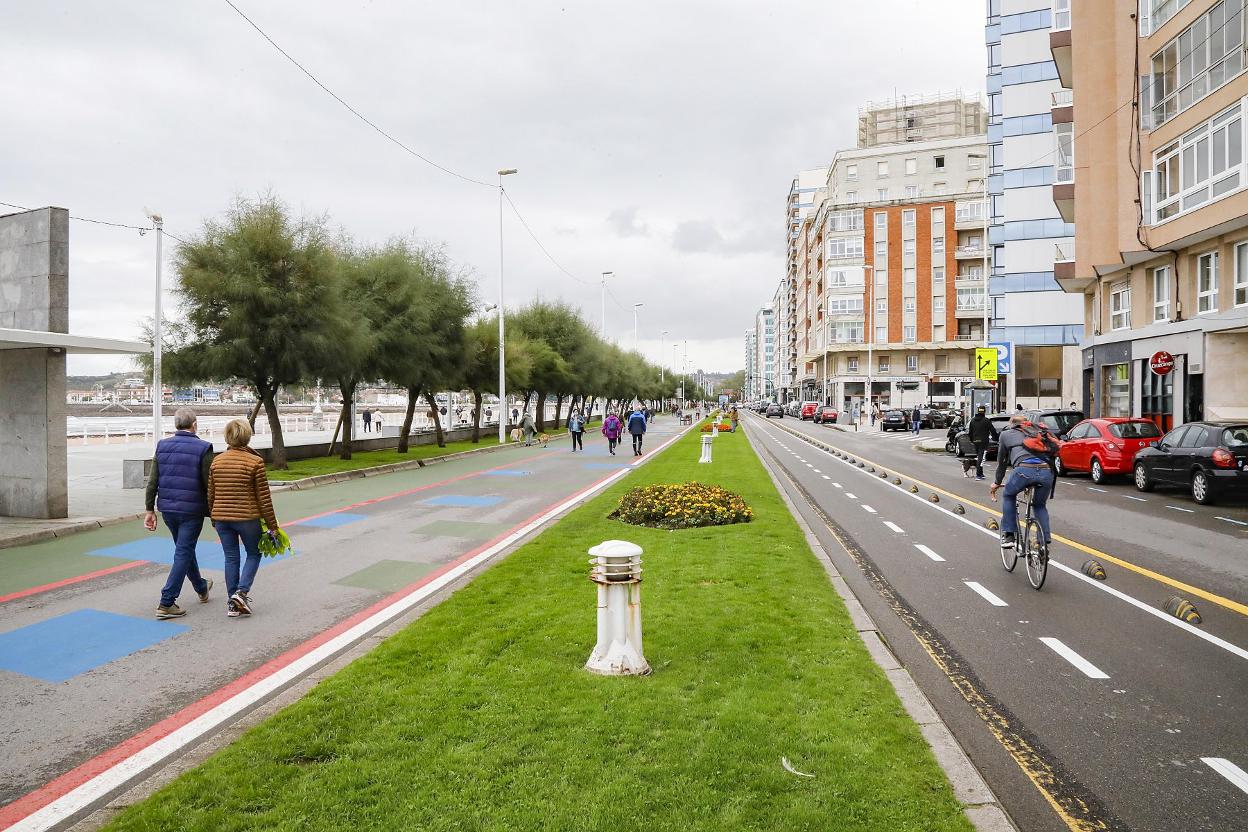Paseantes por la zona conocida como el 'cascayu' desafiando el mal tiempo. 