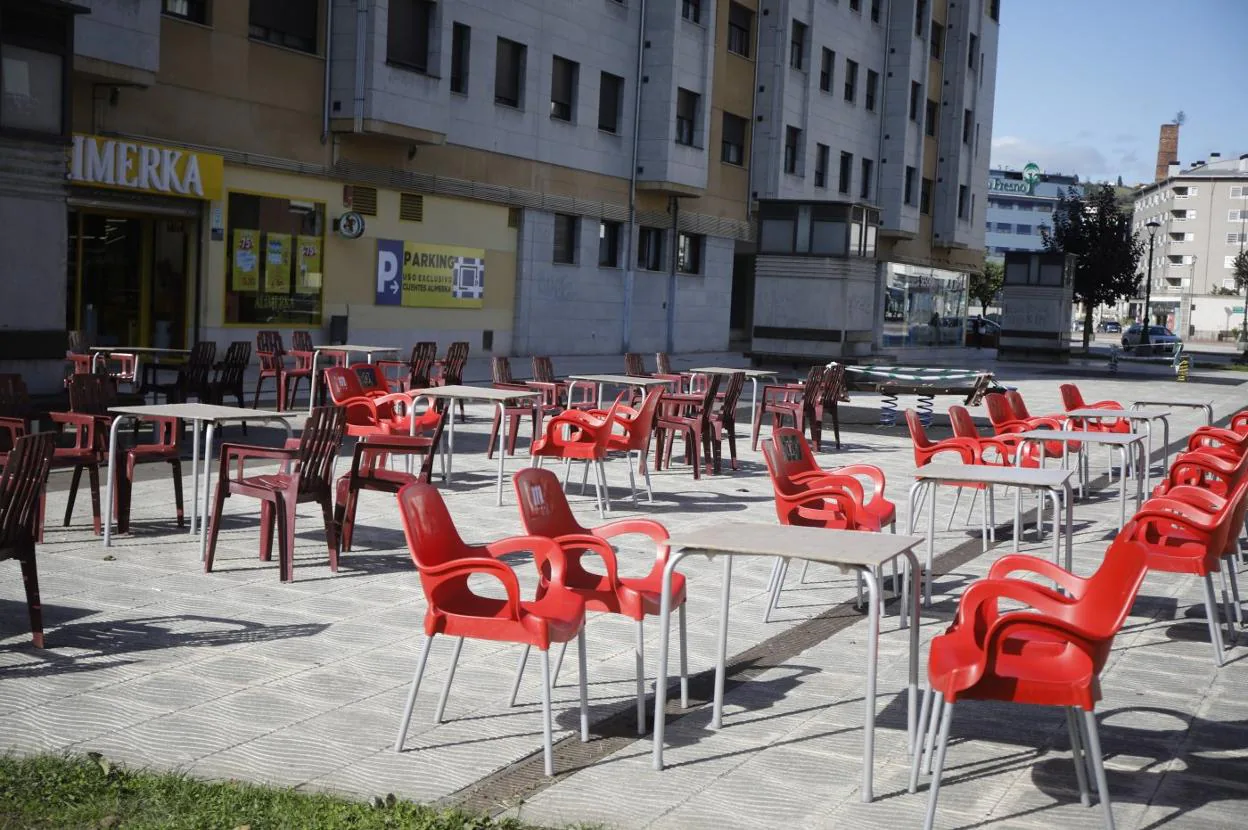 Una de las terrazas habitualmente más concurridas del centro de Langreo, sin clientes. 