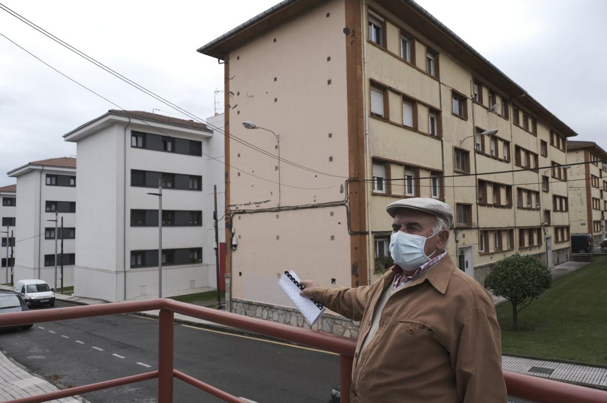 Emilio González, vecino del poblado, ante uno de los bloques que aún no ha sido rehabilitado. 