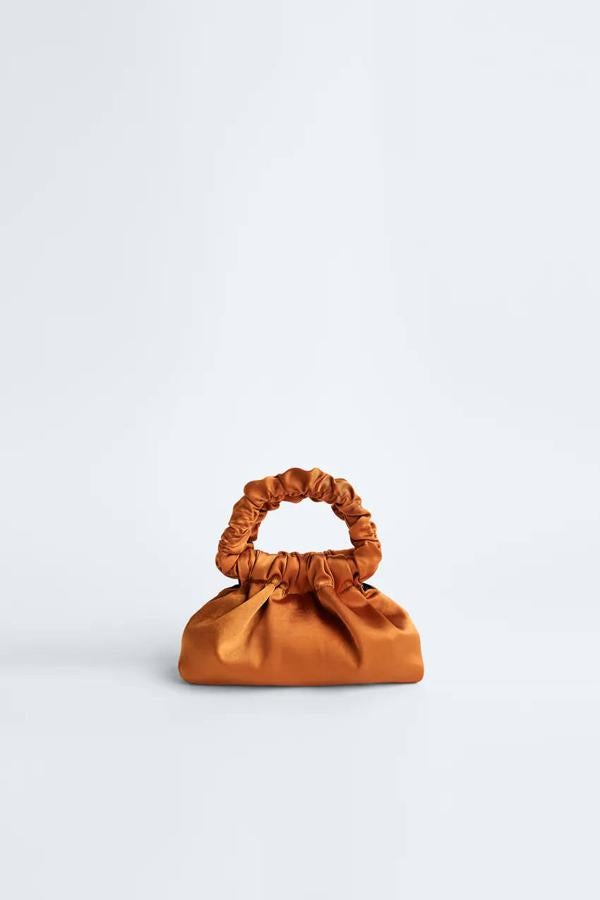 Bolso pequeño y satinado en color naranja de Zara, 19,95 euros.