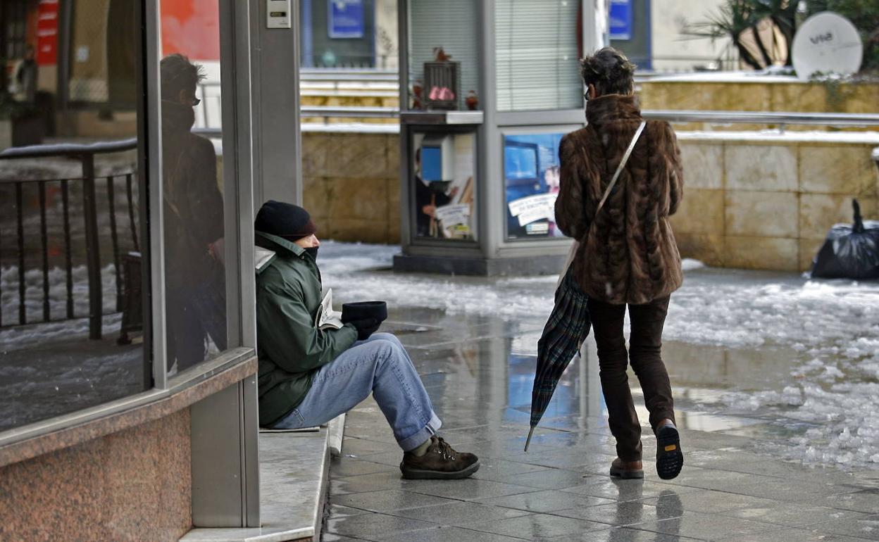 Una persona pide limosna en una calle de Oviedo. 