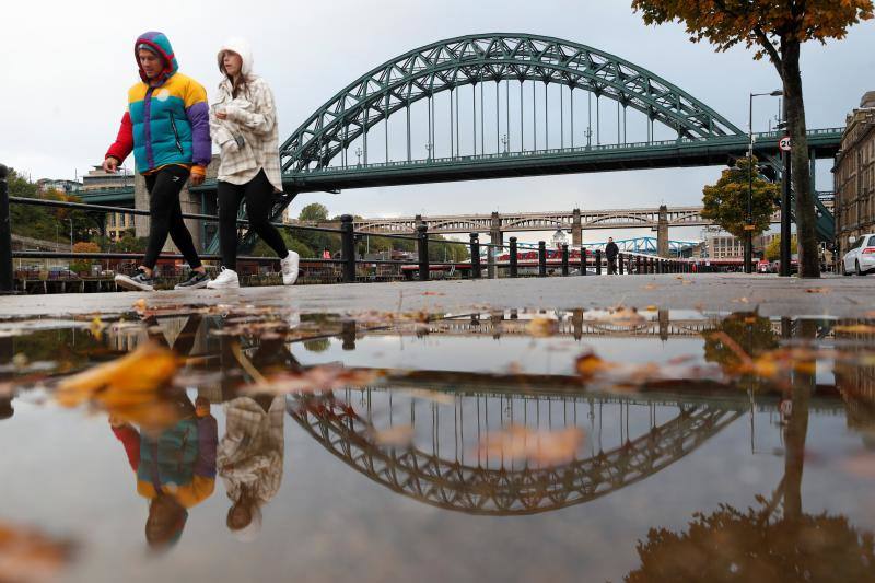 La gente camina mientras las hojas de otoño se ven en el suelo en Quayside en Newcastle Upon Tyne, Gran Bretaña. 