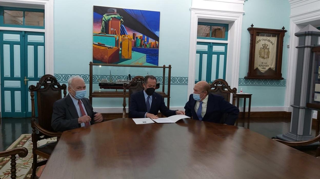 El presidente de la Fundación Archivo de Indianos, Francisco Rodríguez; el presidente de Abanca, Juan Carlos Escotet, y el presidente de la Asociación de Amigos del Archivo y Museo de la Emigración, Antonio Suárez, rubrican la renovación del convenio en la Quinta Guadalupe, en Colombres. 