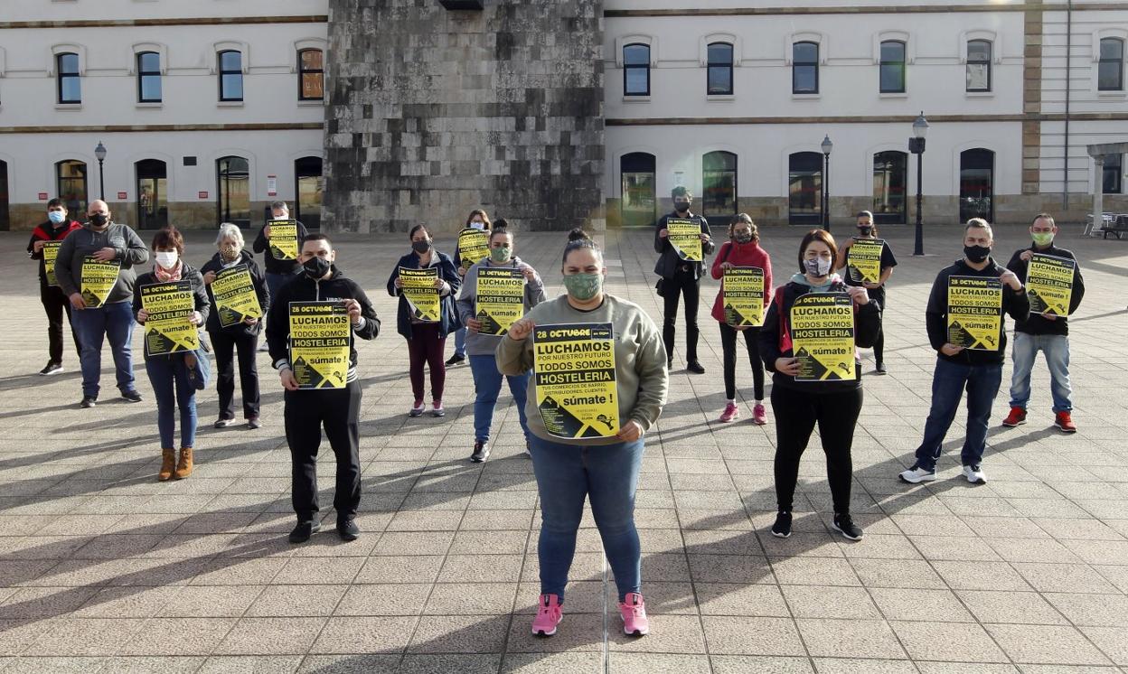 Hosteleros y comerciantes de El Coto, en la plaza de la República, con los carteles que anuncian la movilización del día 28. 