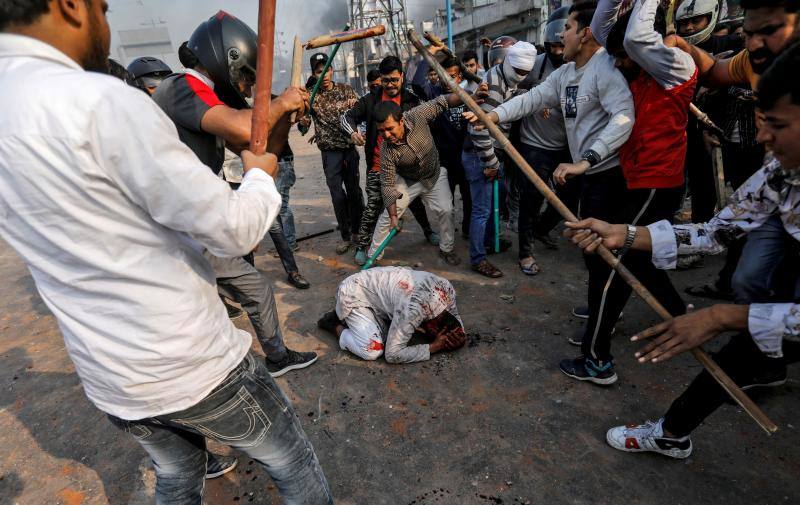 Personas que apoyan la nueva ley de ciudadanía de India golpean a un musulmán durante un enfrentamiento con quienes se oponen a la ley en Nueva Delhi, India, el 24 de febrero de 2020. 