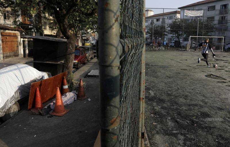 El cuerpo de Valnir Mendes da Silva, de 62 años, yace en una acera de la comunidad de Arara, donde falleció pese a que sus vecinos solicitaron ayuda al servicio de emergencia por presentar problemas respiratorios, durante la pandemia de coronavirus, en Río de Janeiro, Brasil, 17 de mayo de 2020. Según los residentes, se necesitaron unas 30 horas para retirar el cuerpo. 