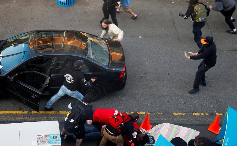 Un hombre armado sale de un vehículo mientras los médicos atienden a Dan Gregory, que fue disparado por un conductor que intentó atravesar con su coche una protesta contra el racismo a raíz de la muerte de George Floyd. En Seattle, Washington, EE UU, 7 de junio de 2020. 