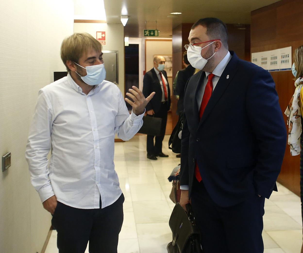 El líder de Podemos, Daniel Ripa, conversa con el presidente del Principado, Adrián Barbón. 