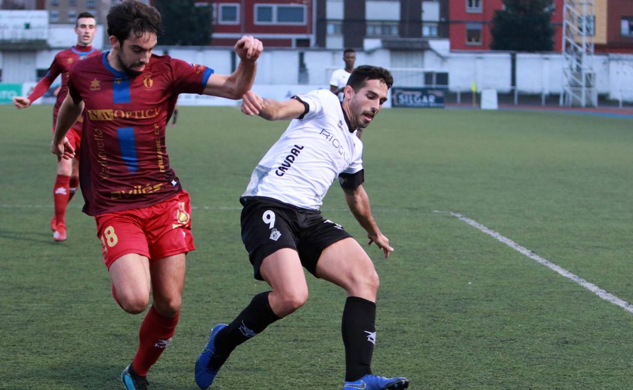 Borja Navarro, del Caudal, controla el balón ante Santa, del Navarro. 