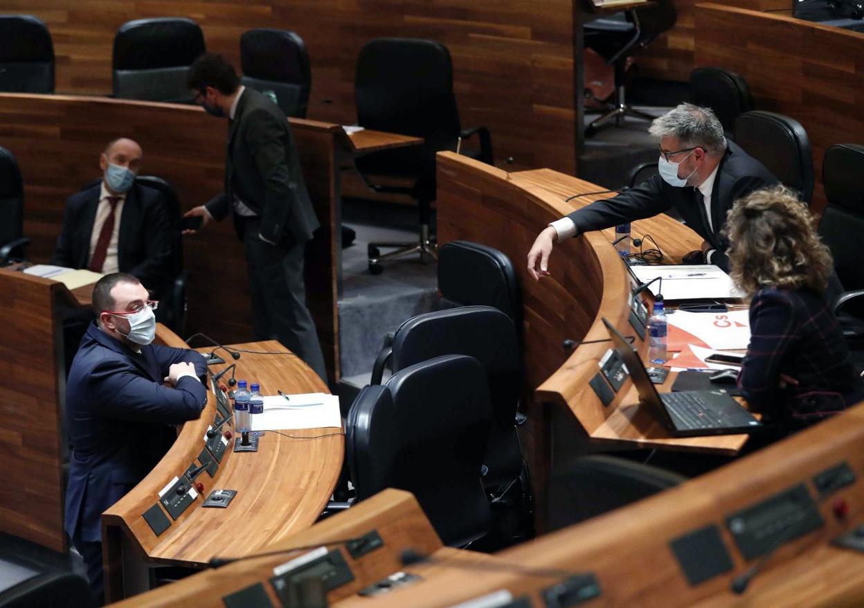 El presidente autonómico, Adrián Barbón, conversa en un pleno con la bancada de Ciudadanos. 