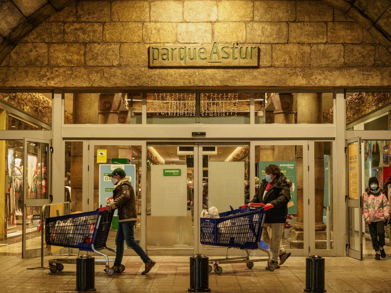 Dos personas con carritos a la salida de ParqueAstur. 