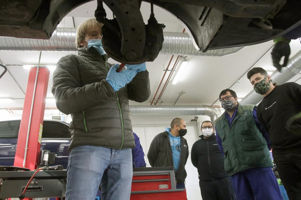 Jesús Urchés explica a los alumnos de la Escuela del Automóvil cómo realizar una modificación en la rueda de un vehículo. 