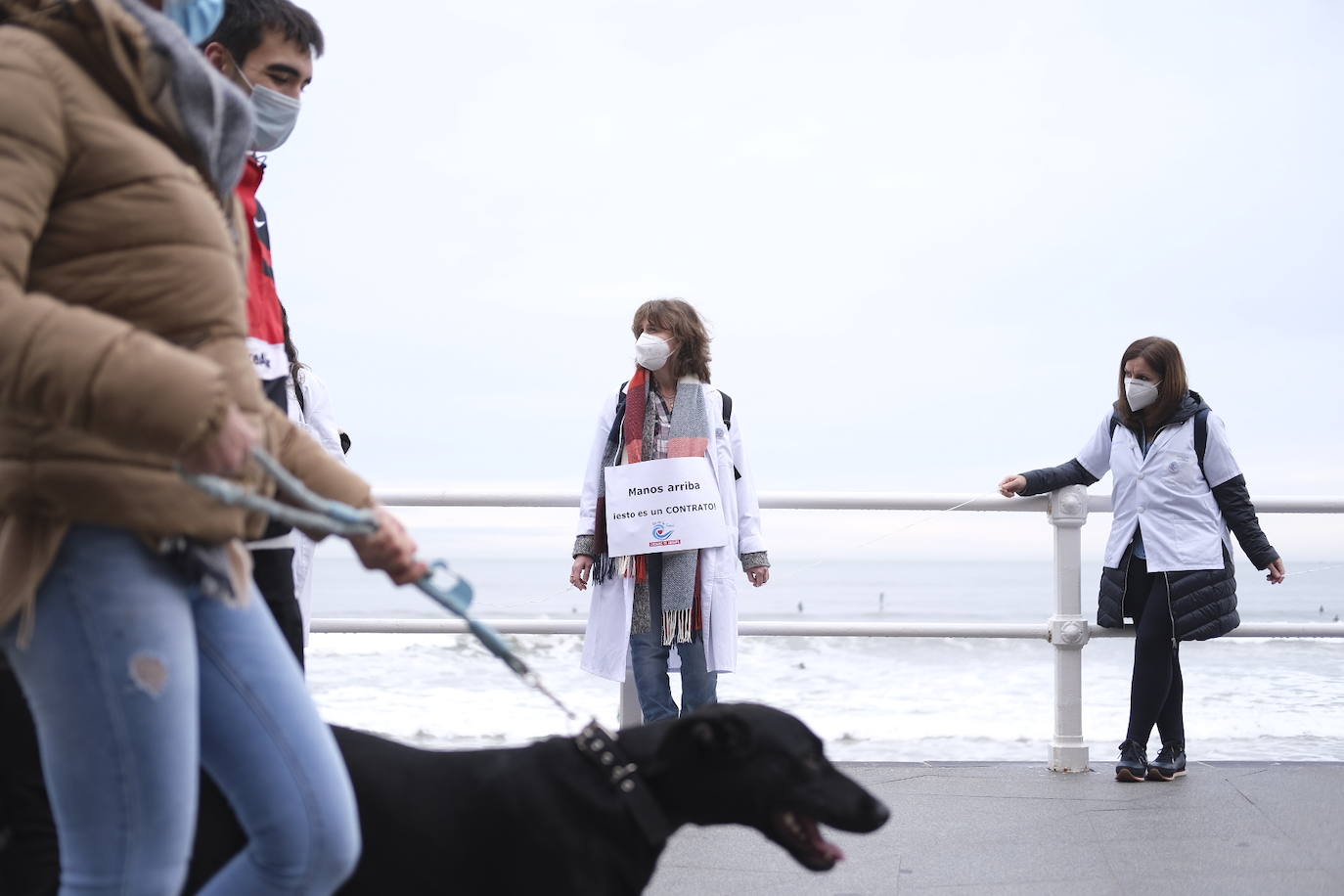 Decenas de personas se han sumado a una cadena humana en el muro de San Lorenzo, en Gijón. Se trata de una iniciativa en defensa de la sanidad pública.