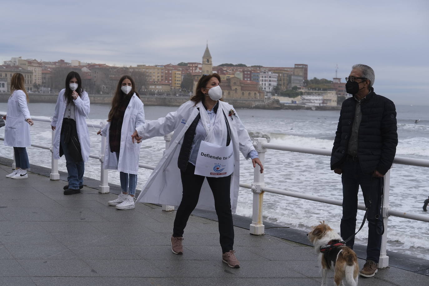 Decenas de personas se han sumado a una cadena humana en el muro de San Lorenzo, en Gijón. Se trata de una iniciativa en defensa de la sanidad pública.