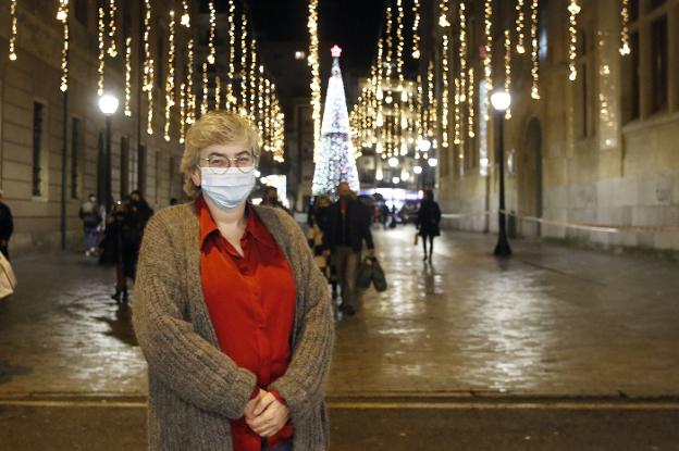 La alcaldesa, frente a la calle de Francisco Tomás y Valiente, con la iluminación y el árbol de Navidad de la plaza del Parchís al fondo. En el vídeo, mensaje de Ana González a los gijoneses de cara a la Navidad.