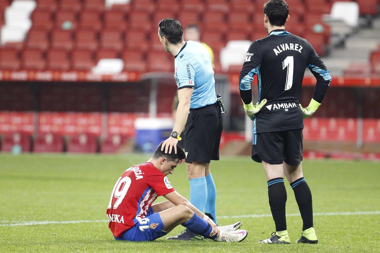 El árbitro consuela a Manu García después de su lesión. 