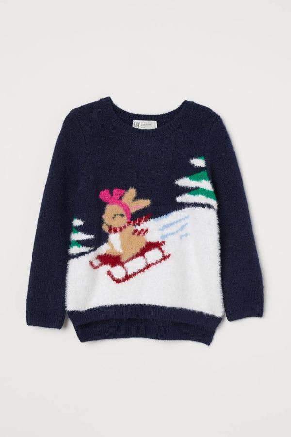 Jersey de niña con estampado navideño sobre fondo blanco y azul marino de H&M (19,99 euros).