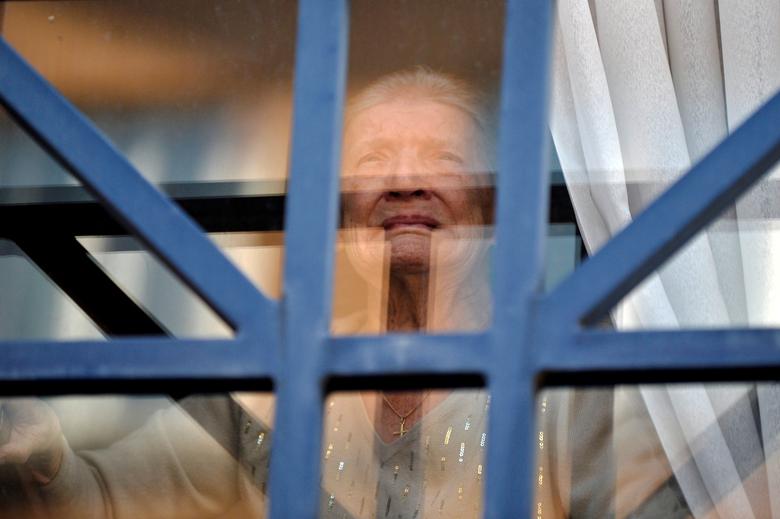 Bélgica | Louise Gombeer, que sufría el coronavirus, mira por la ventana en su cumpleaños número 100 en la residencia para ancianos "Melopee" en Bruselas.