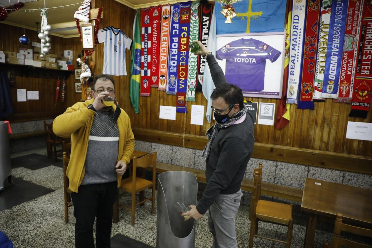 Pablo Candanedo bebe un culín mientras su compañero Chus Braña escancia, ayer en Langreo. 