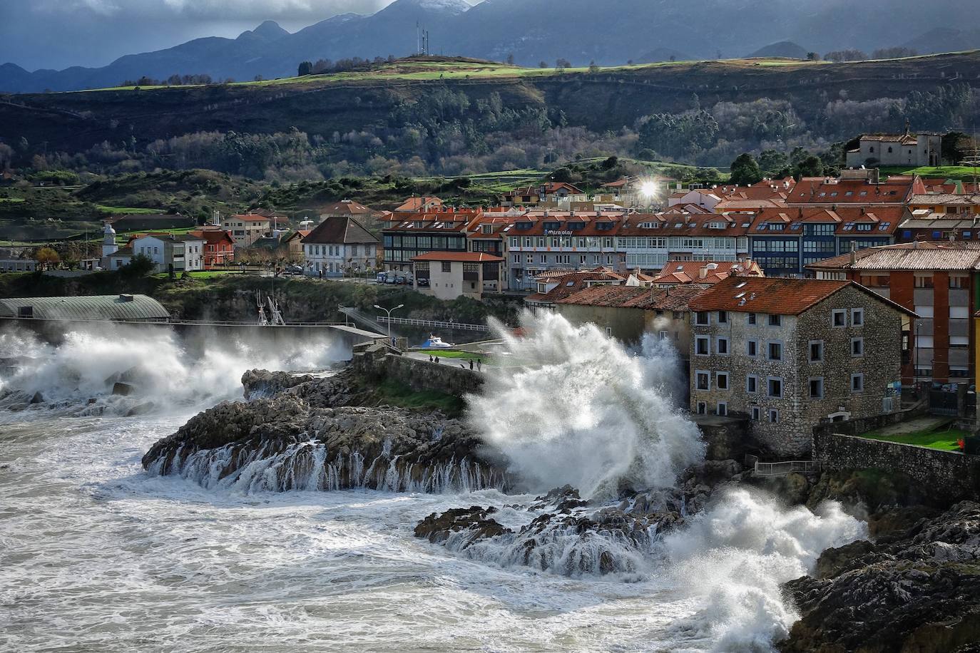 La borrasca 'Bella' ha provocado más de 1.900 incidencias en Asturias y complica las comunicaciones. La nieve acumulada en las últimas horas, que ha cerrado el puerto del Connio, obliga a usar cadenas en 15 altos de montaña. Los fuertes vientos han procovado la caída de árboles y la Aemet mantiene el litoral del Principado en alerta roja por olas de hasta diez metros 