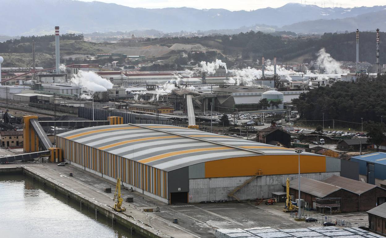 Imagen general de Asturiana de Zinc, con una de sus naves portuarias en primer término.