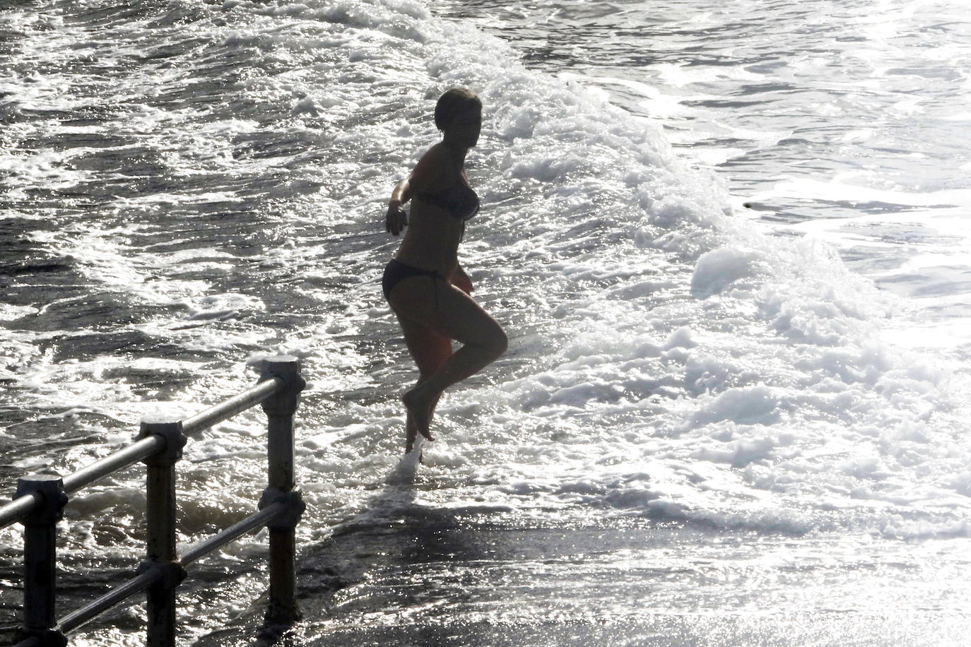 El frío no ha podido con los valientes que han decidido darse un chapuzón en la playa de San Lorenzo, de Gijón, durante este frío día de Reyes. En la mañana de este miércoles las temperaturas máximas apenas han superado los 8 grados. 