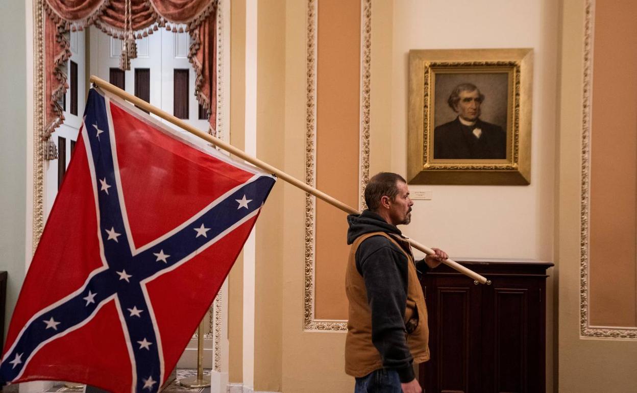 Un seguidor de Donald Trump irrumpe en el Capitolio de los Estados Unidos con una bandera de los Estados Confederados .