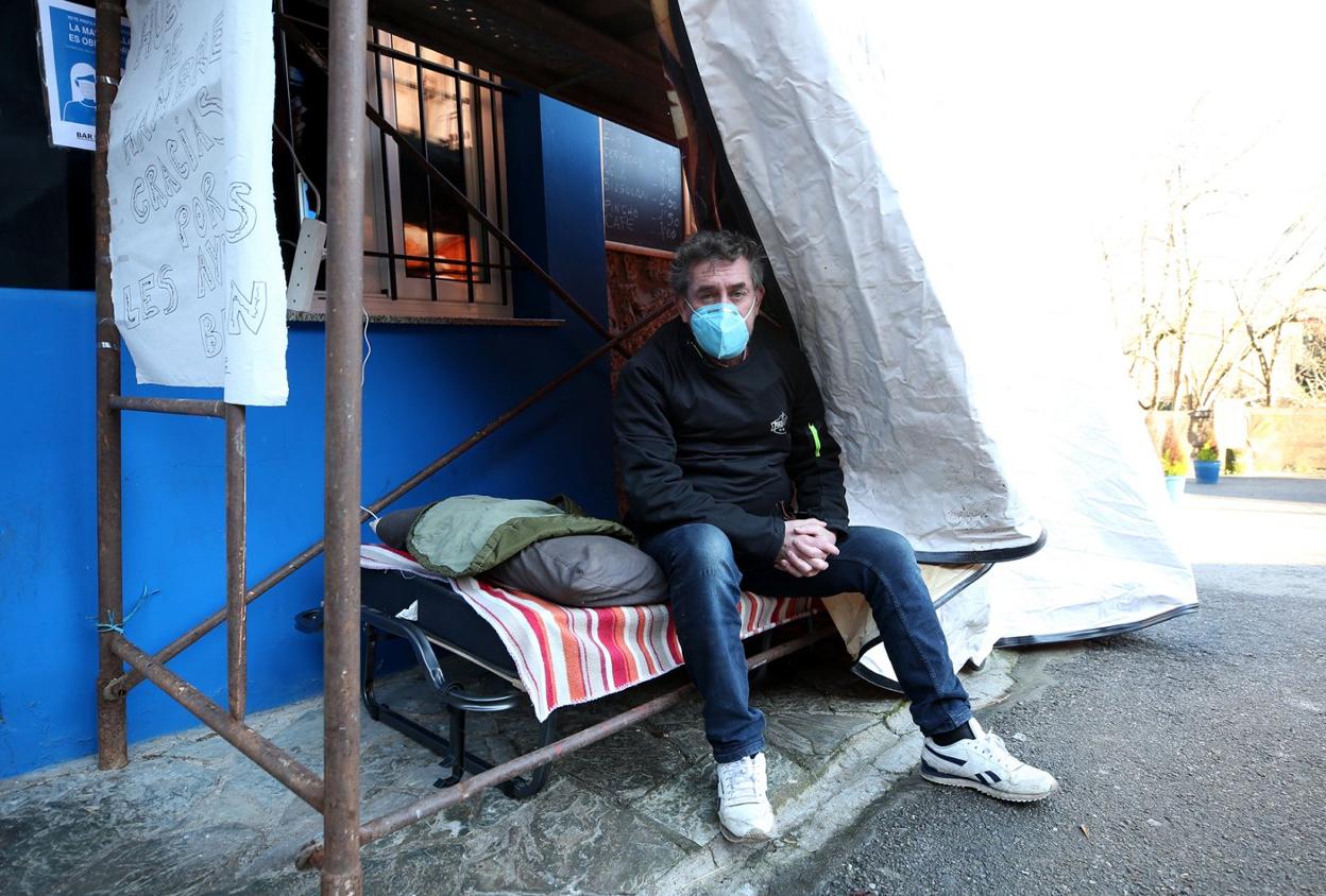 Sergio Villaverde, el hostelero riberano en huelga de hambre, en el camastro frente a su local. 