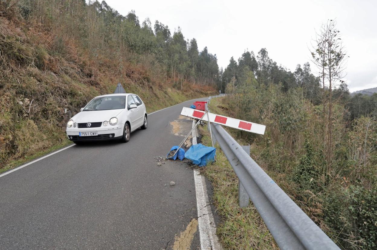 Un coche circula por una zona afectada por un hundimiento.