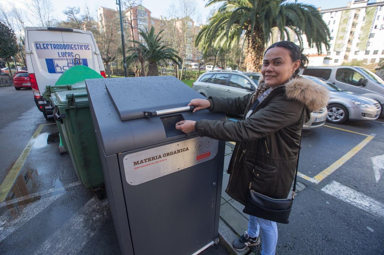 Una vecina deposita basura orgánica en un contenedor. 