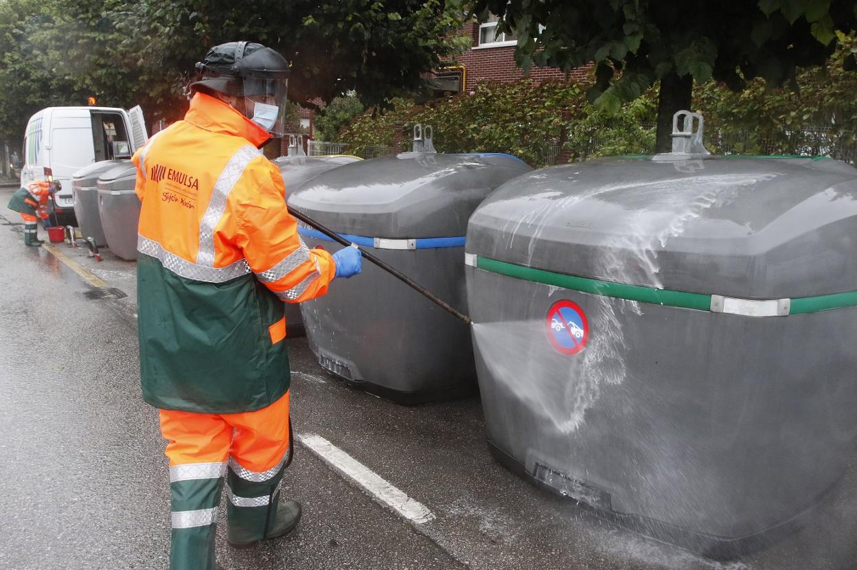 Un emisario de Emulsa desinfecta unos contenedores. 
